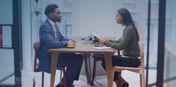 recruiter and candidate sitting across from each other talking about a job